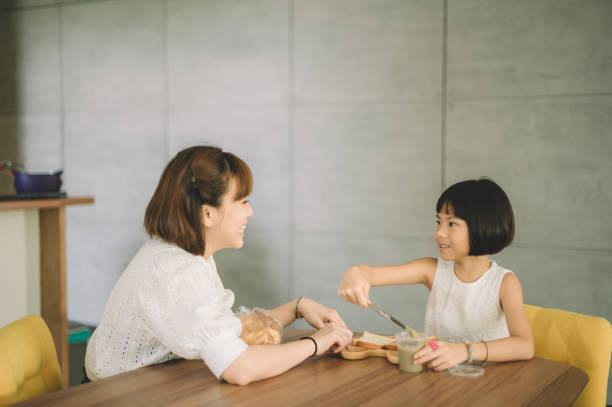 an asian chinese mother spending time together with her daughter at home during weekend leisure bonding time